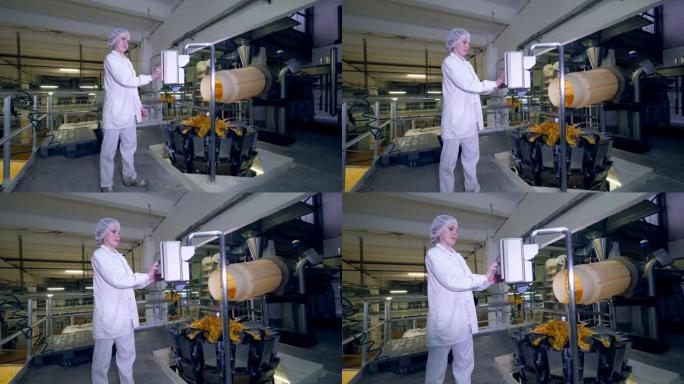 一个人在工厂机器上工作，而薯片在传送带上移动。
