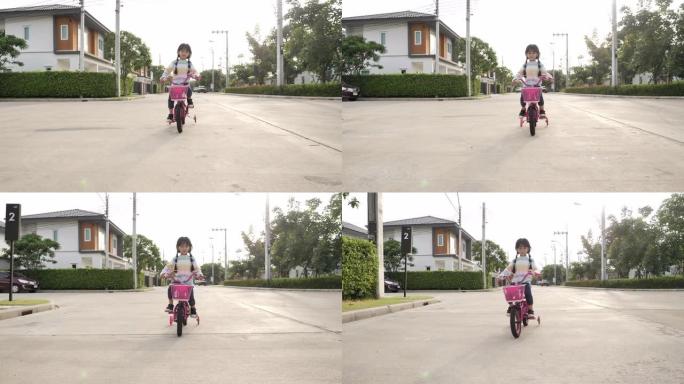 亚洲小女孩在街上骑自行车。