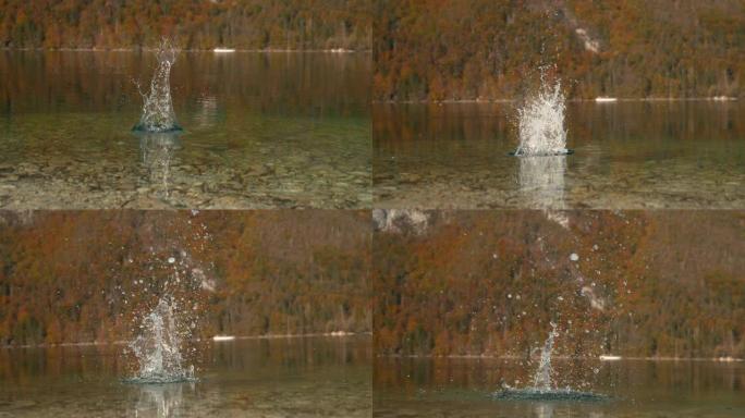 特写: 一块石头掉入湖中后，玻璃状的水在空中飞起来