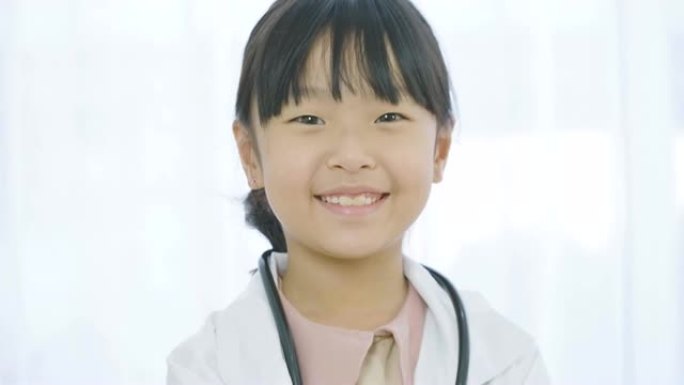 穿着白大褂的年轻小女孩医生的肖像，听诊器看着相机。