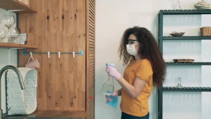 一个女人正在她的公寓里给衣柜消毒。新型冠状病毒肺炎锁定概念。