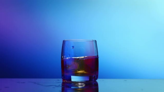 威士忌加冰，玻璃飞溅，蓝色背景