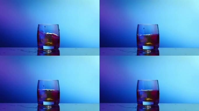 威士忌加冰，玻璃飞溅，蓝色背景