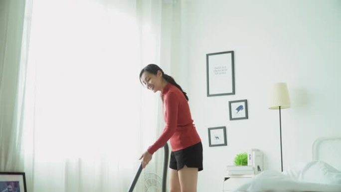 女人用吸尘器打扫家庭