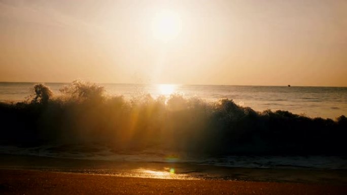 美丽的背景镜头在神奇的海洋度假海滩拍摄田园诗般的金色日落，大浪来了。
