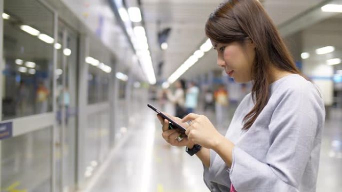 在地铁站使用电话女生看手机实拍