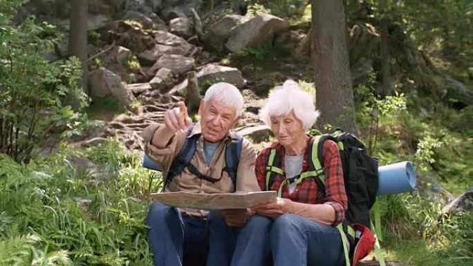 远足期间使用地图的老年夫妇