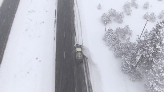 空中: 暴风雪期间，扫雪卡车清除并在高速公路上撒盐。