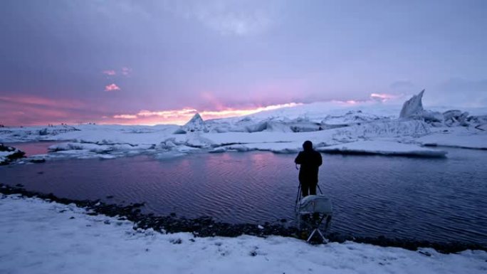 WS摄影师，带相机和三脚架，拍摄冰岛Jokulsarlon泻湖