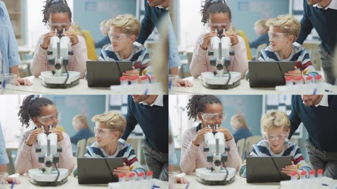 小学科学教室: 可爱的小女孩在显微镜下看，男孩在互联网上使用数字平板电脑检查信息，而热情的老师解释课