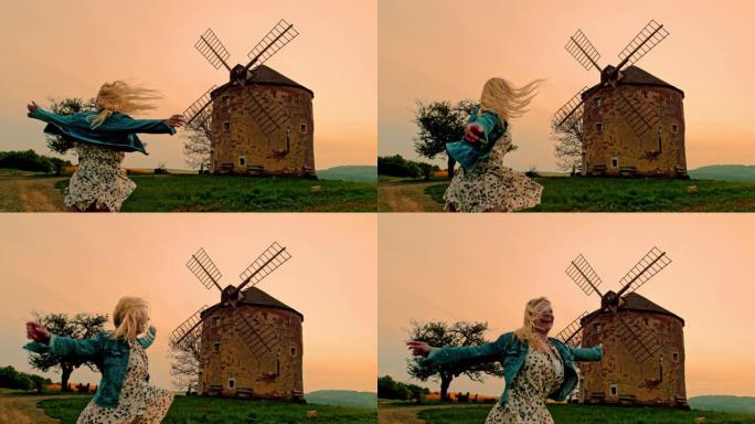 在摩拉维亚乡村的风车下，超级SLO MO开朗的女人在旋转