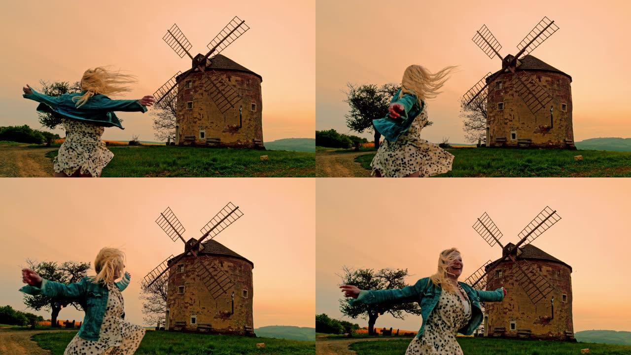 在摩拉维亚乡村的风车下，超级SLO MO开朗的女人在旋转