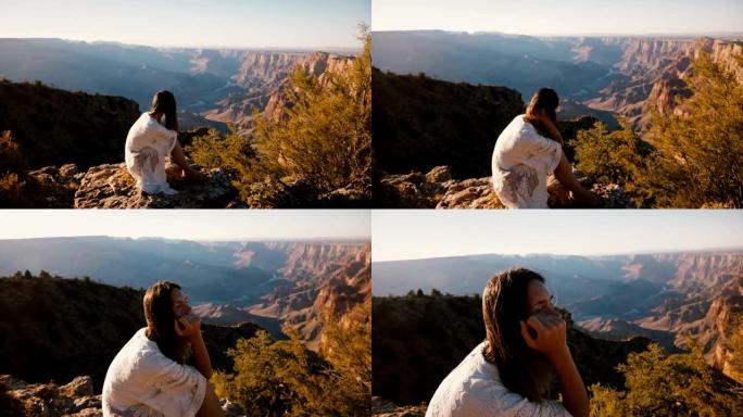 相机放大了平静的年轻女子，头发飞舞，在大峡谷慢动作上观看史诗般的日落全景。