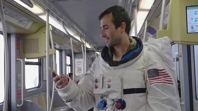 一名穿着衣服的宇航员使用智能手机打电话和发送信息。宇航员一边微笑，一边看着手中的电话。概念: 电话促