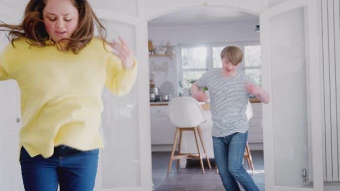 年轻的唐斯综合症夫妇在一起在家里跳舞很开心