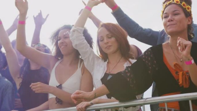 一群年轻的朋友在音乐节现场的障碍物后面跳舞，以慢动作的烟雾射击