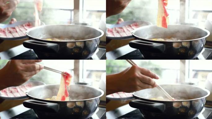 用筷子、沙锅和寿喜烧搅拌的煮汤火锅蘸肉片的4k慢动作镜头日式美食概念