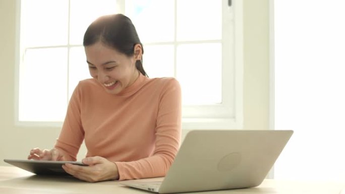 亚洲女性使用数字平板电脑和家庭。