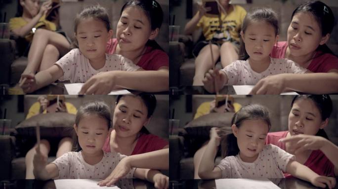 亚洲母亲和小女孩在客厅在家上学