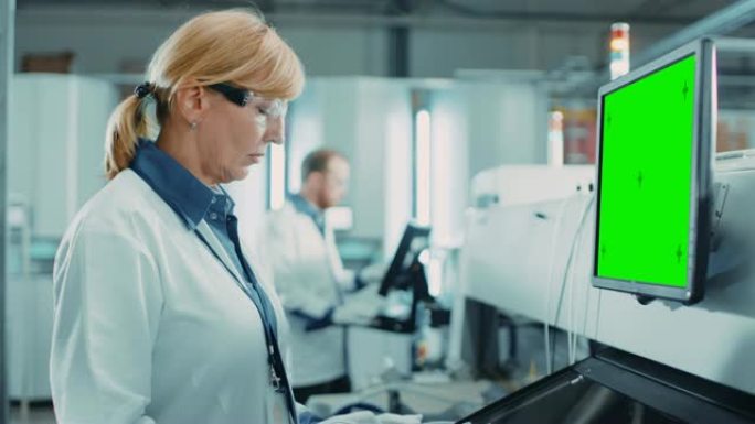 在高科技工厂，女工程师使用绿屏计算机对印刷电路板表面安装装配线进行编程拾取和放置电子机械。