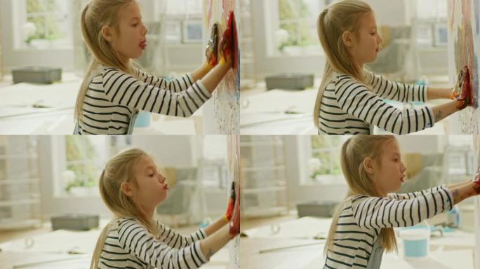 快乐的小女孩，双手蘸上生动的油漆，在墙上画出五颜六色的抽象。她玩得很开心，笑得很开心。家正在装修。