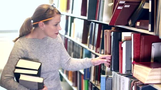 成熟的女人在图书馆寻找书籍