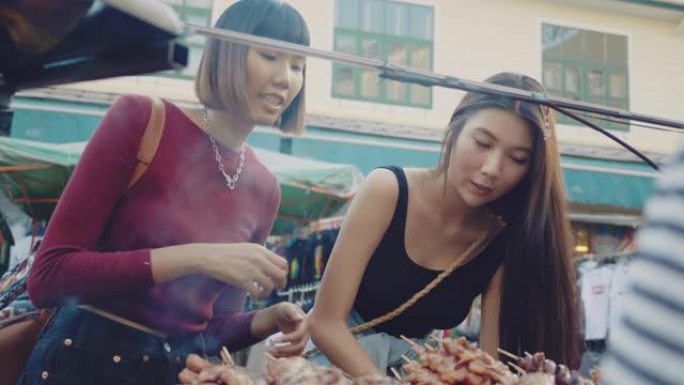 两名年轻女子在考山路享受街头美食。