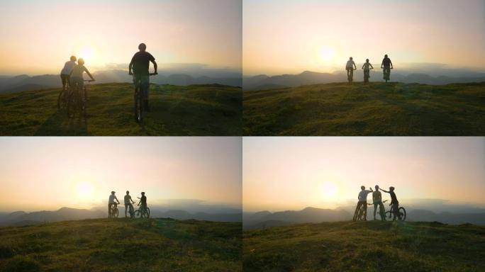 空中: 三名越野骑自行车的人骑到山坡和高高的五指边缘