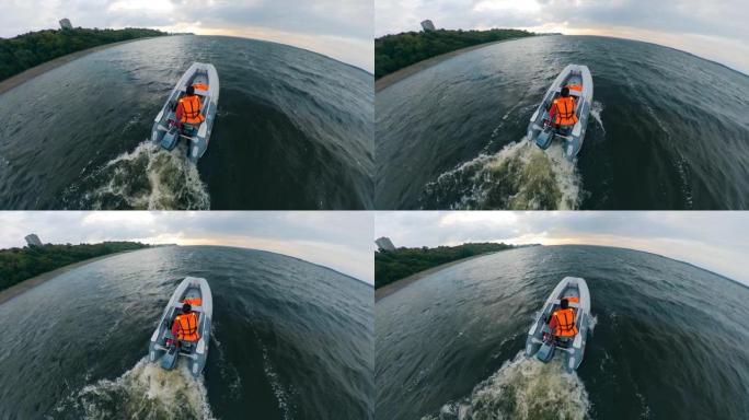 船夫在水上驾驶充气船。男子漂浮在摩托艇上