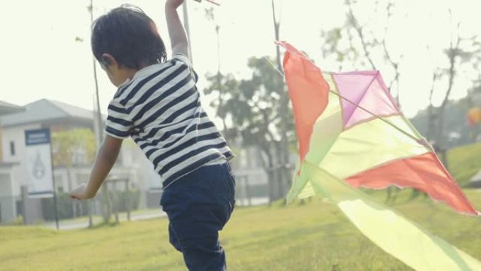 亚洲小男孩在阳光明媚的日子跑步风筝自由概念夏季自然场。