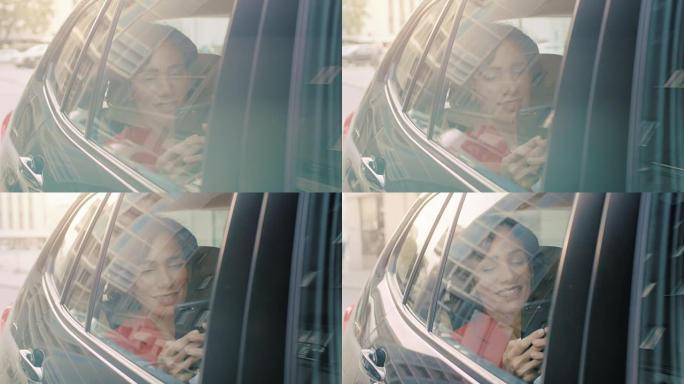 美丽的女人坐在汽车上，坐在乘客后座上使用智能手机，浏览互联网，与朋友聊天。从车外拍摄的摄像机。