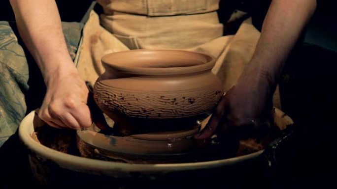 陶器工人使用特殊的线条从轮子上取下花瓶。