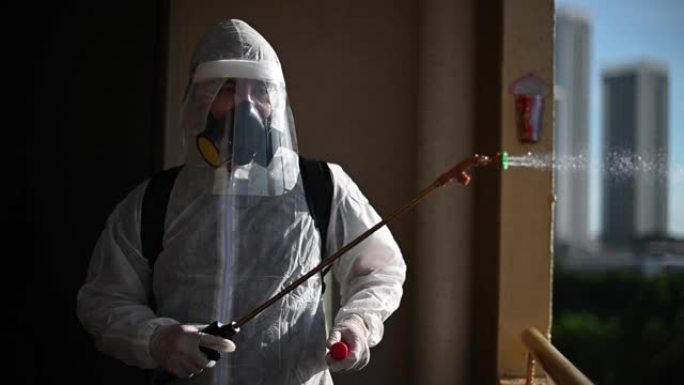 一名穿着防护服的人喷洒房屋并消毒房屋灭虫病毒