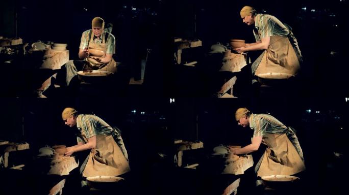 专业陶工从轮子上取下锅。