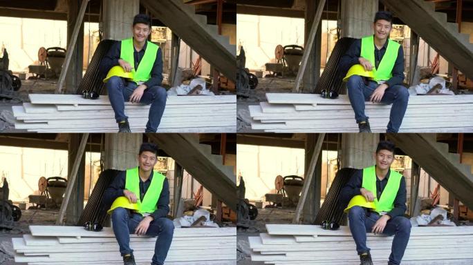 微笑的年轻建筑承包商坐在木板上