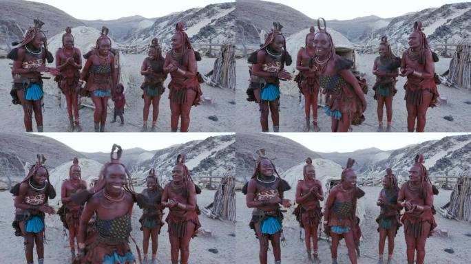 纳米比亚，穿着传统服装的辛巴族妇女在他们的粘土小屋外跳舞唱歌的4K画面