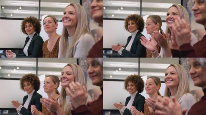 现代办公室的女企业家队伍为同事的演讲鼓掌