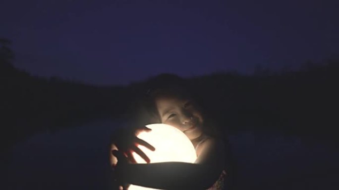 抱着月亮的女孩童真好奇发光球