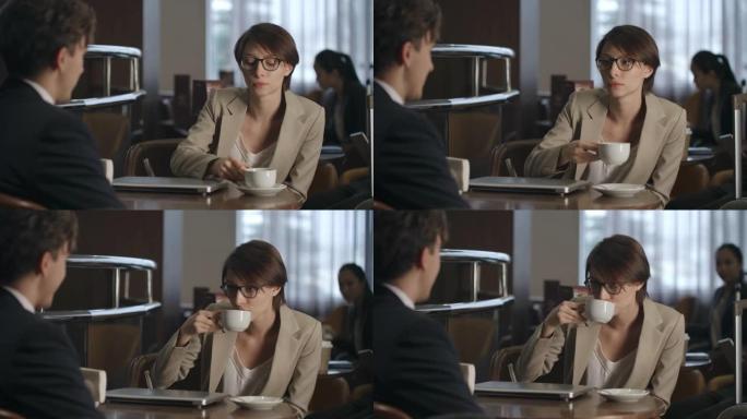 商务小姐在喝咖啡时与同事交谈