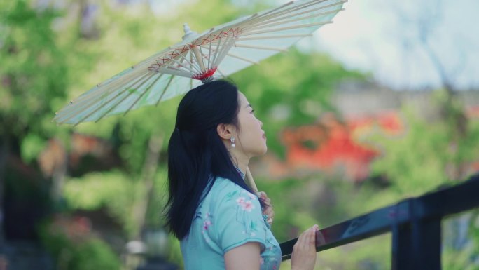穿旗袍女生撑着油纸伞仰望天空传统服饰文化