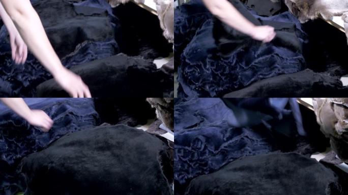 一个人打包动物皮肤。工厂工人将皮革堆放成堆的衣服。