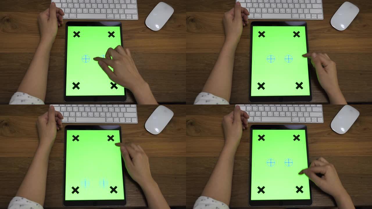 女人在办公桌上使用数字平板电脑绿屏