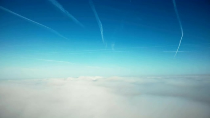 电影空中拍摄，在云层上飞升，朝着阳光明媚的地平线和晴朗的蓝天，自由的概念。
