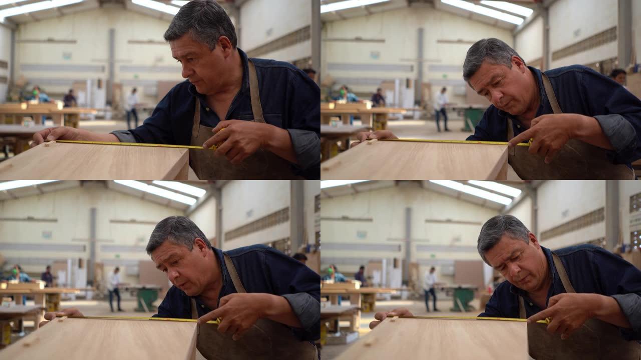 专注的男性木匠用卷尺测量木箱