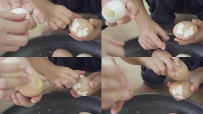 女性和孩子的手剥煮鸡蛋。