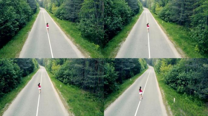 鸟瞰图的森林道路和一个苗条的年轻女子在其中奔跑