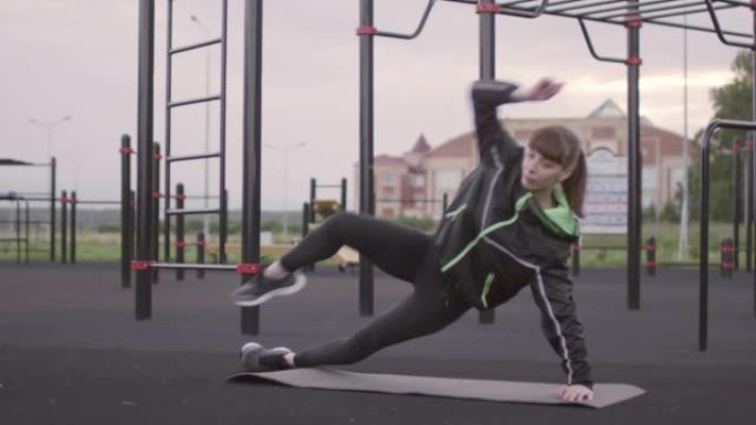 运动女人在户外锻炼时做侧木板嘎吱嘎吱