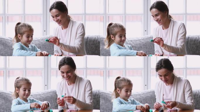小学龄前女孩和妈妈玩橡皮泥。
