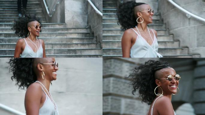时尚年轻的黑人妇女戴着墨镜走在城市街道的楼梯上，特写