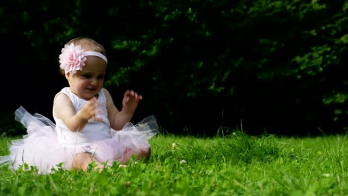 在一个阳光明媚的春天，一个小女孩打扮得像芭蕾舞演员一样，自己在花园里旋转，微笑着快乐
